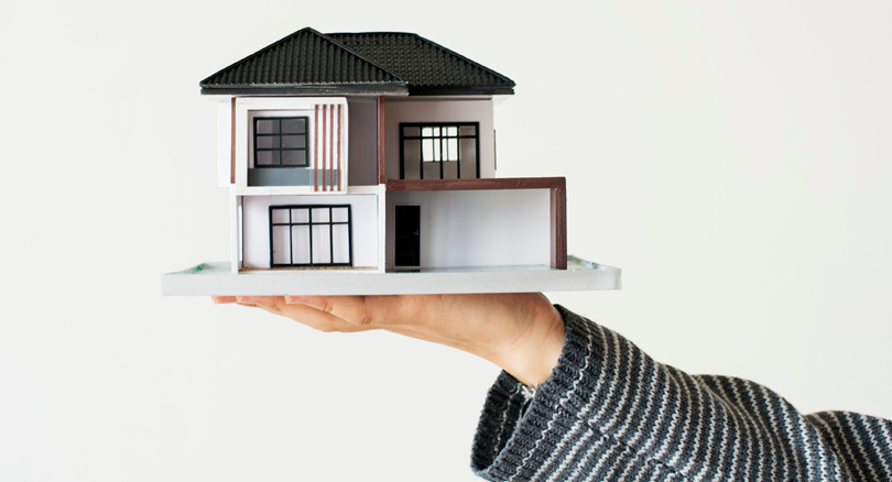 mano sujetando una maqueta de una casa